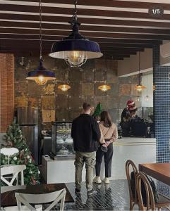 a man and a woman standing at a counter in a restaurant at Khunluang Hostel in Chiang Mai