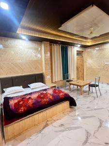 1 dormitorio con 1 cama en una habitación con mesa en Majestic Mountain Bhaiji Guest House, en Kasol