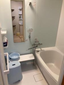 La salle de bains est pourvue d'une baignoire, de toilettes et d'un lavabo. dans l'établissement 民宿ニュー万福茶屋, à Taketa