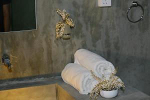 baño con un rollo de toallas y una planta en Yala Wild Hut - Yala en Tissamaharama