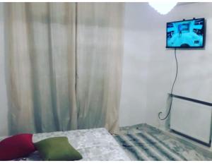 a bedroom with a bed and a tv on the wall at Studio apartment beach front in Harqalah
