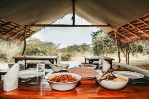 un tavolo con ciotole di cibo in cima di Yala Wild Hut - Yala a Tissamaharama