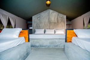 two beds in a room with two bedsitures at Yala Wild Hut - Yala in Tissamaharama