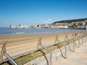 a beach with a row of metal hand rails at Eton Cottage in Minehead