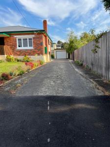 an empty driveway in front of a house at A lovely studio in Kings Meadows in Kings Meadows
