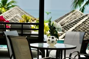 una mesa con un jarrón de flores en un patio en 3 Bedroom Seaview Villa Halo on Beachfront Resort en Koh Samui