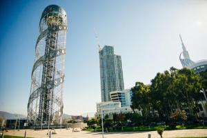 uma torre de vidro alta numa cidade com edifícios em Batumi Porta Tower 1611 em Batumi