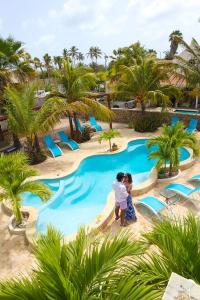 two children standing in front of a swimming pool at a resort at Aqua Viva Suites in Kralendijk