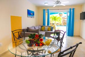 una sala de estar con una mesa de cristal con fruta. en Aqua Viva Suites en Kralendijk