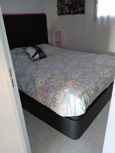 - un lit avec une couette colorée dans une chambre dans l'établissement Charmant T 2, vue mer imprenable, à La Seyne-sur-Mer