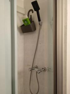 La salle de bains est pourvue d'une douche avec un pommeau de douche. dans l'établissement Charmant T 2, vue mer imprenable, à La Seyne-sur-Mer