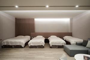 a room with four beds and a couch at Yung An Business Hotel in Dounan