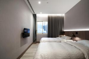 a hotel room with two beds and a tv at Yung An Business Hotel in Dounan