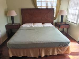1 dormitorio con 1 cama grande y 2 mesitas de noche en Aanola Villas 6b Tranquil Privy Boudoir, en Charlotte
