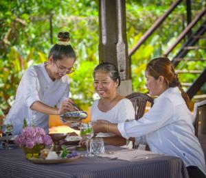a group of three women sitting at a table at Chef Nak Luxury Homestay in Phnom Penh