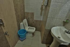 a bathroom with a toilet and a sink at Hotel Haridev in Roorkee +13 photos