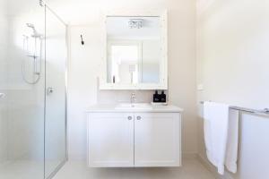 a white bathroom with a sink and a mirror at Bridgewater in Bright