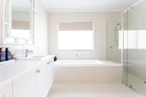 a white bathroom with a tub and a sink at Bridgewater in Bright
