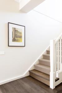 a white staircase in a house with a picture on the wall at Bridgewater in Bright