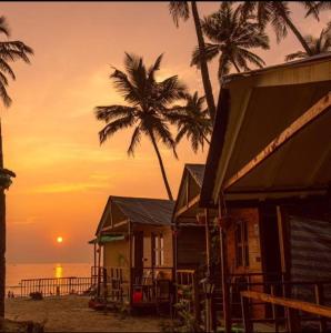 a group of houses on the beach at sunset at Palolem Beach View Inn in Palolem