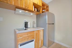 a kitchen with a stainless steel refrigerator and wooden cabinets at Elegant Brickell Miami Apartment in Miami