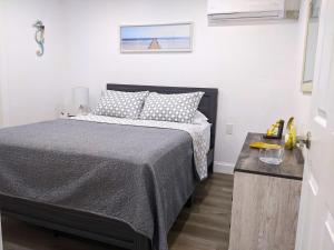 1 dormitorio con 1 cama en una habitación blanca en Sea Breezes Holiday, A Charming Suite Near The Beaches, en Holiday