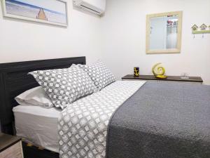 1 dormitorio con cama y espejo en la pared en Sea Breezes Holiday, A Charming Suite Near The Beaches, en Holiday