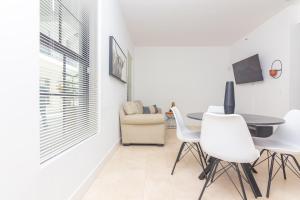 comedor con mesa y sillas blancas en Miami Downtown Modern Apartment - 5 minutes to Wynwood - 10 minutes to South Beach, en Miami