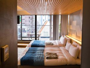 um quarto de hotel com uma cama grande e uma varanda em Asakusa Kokono Club Hotel em Tóquio