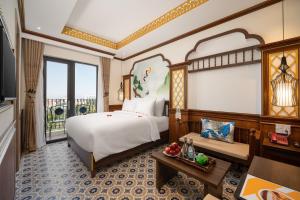 a hotel room with a bed and a window at Hoi An Babylon Riverside Hotel & Spa in Hoi An