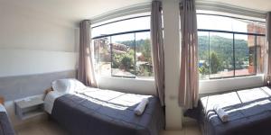 - une chambre avec 2 lits et une grande fenêtre dans l'établissement QALA CHAKIS WASI, à Cusco