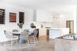 a kitchen and dining room with a table and chairs at Casa De Palmeras in Casuarina