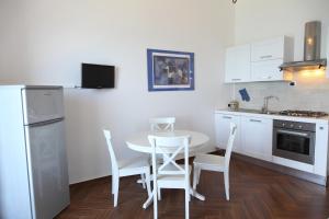 een witte keuken met een tafel en stoelen. bij Appartamenti Giudecca - by Vacation Service in Cefalù