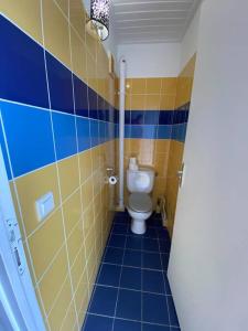 a bathroom with a toilet and blue tiles at Blue Dream Paradise - Résidence plage & piscine in Grand-Bourg