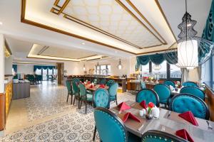 een eetkamer met blauwe stoelen en tafels bij Hoi An Babylon Riverside Hotel & Spa in Hội An