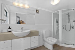 ein weißes Badezimmer mit Waschbecken und Toilette in der Unterkunft Blue Skies Sunrise - Mangawhai Heads Holiday Home in Mangawhai + 19 Fotos