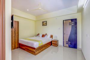 a bedroom with a bed and a sliding door at OYO Capital O Swayamkrushi Arcade in Bangalore