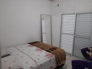 um quarto com uma cama e duas janelas em Sobrado com 3 quartos em São Paulo
