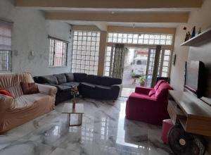 uma grande sala de estar com sofás e uma televisão em Sobrado com 3 quartos em São Paulo