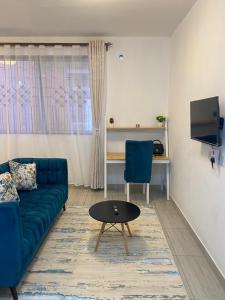a living room with a blue couch and a table at Love-tribe studio apartment in Mombasa