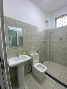 a bathroom with a toilet and a sink and a shower at Love-tribe studio apartment in Mombasa