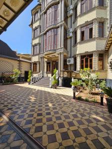 a building with a checkered floor in front of it at Hotel Sharq in Dushanbe