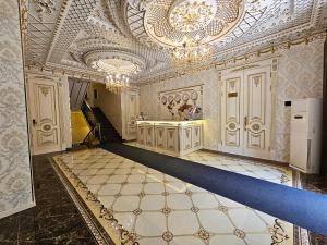 a large room with a ceiling and a staircase at Hotel Sharq in Dushanbe