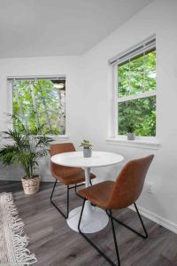 a white table and chairs in a room with two windows at Private Newly Renovated Studio w private Parking! in Portland