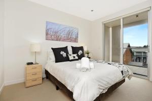 um quarto com uma cama grande e uma janela em 25 The Breeze - unit 25 at nr 2-5 Flinders Pde, Victor Harbor em Victor Harbor