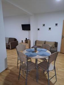 ein Wohnzimmer mit einem Tisch, Stühlen und einem Sofa in der Unterkunft Tratinčica in Tjentište