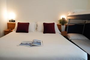 a bedroom with a bed with a book on it at Hotel Sunset in Rimini