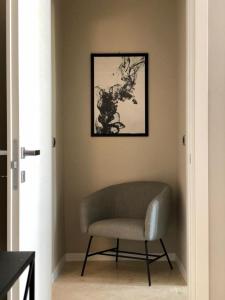 LAUS VIA SPARANO APP.2- LUX & DESIGN NEW! في باري: كرسي في غرفة مع صورة على الحائط