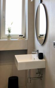 W łazience znajduje się biała umywalka i lustro. w obiekcie LAUS VIA SPARANO APP.2- LUX & DESIGN NEW! w mieście Bari