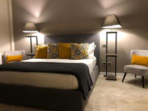 LAUS VIA SPARANO APP.2- LUX & DESIGN NEW! في باري: غرفة نوم بسرير ومصباحين وكرسي